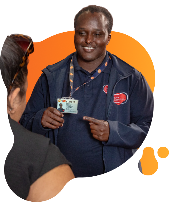 Person holding up a staff ID badge while speaking to another person indoors, with Insite Installations branding visible on their clothing.