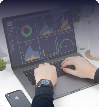 Person using a laptop displaying the VANTAGE client portal dashboard, with charts and performance graphs visible on the screen.