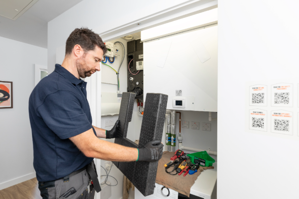 Engineer servicing a heat interface unit as part of heat network responsibilities in a resident’s home.