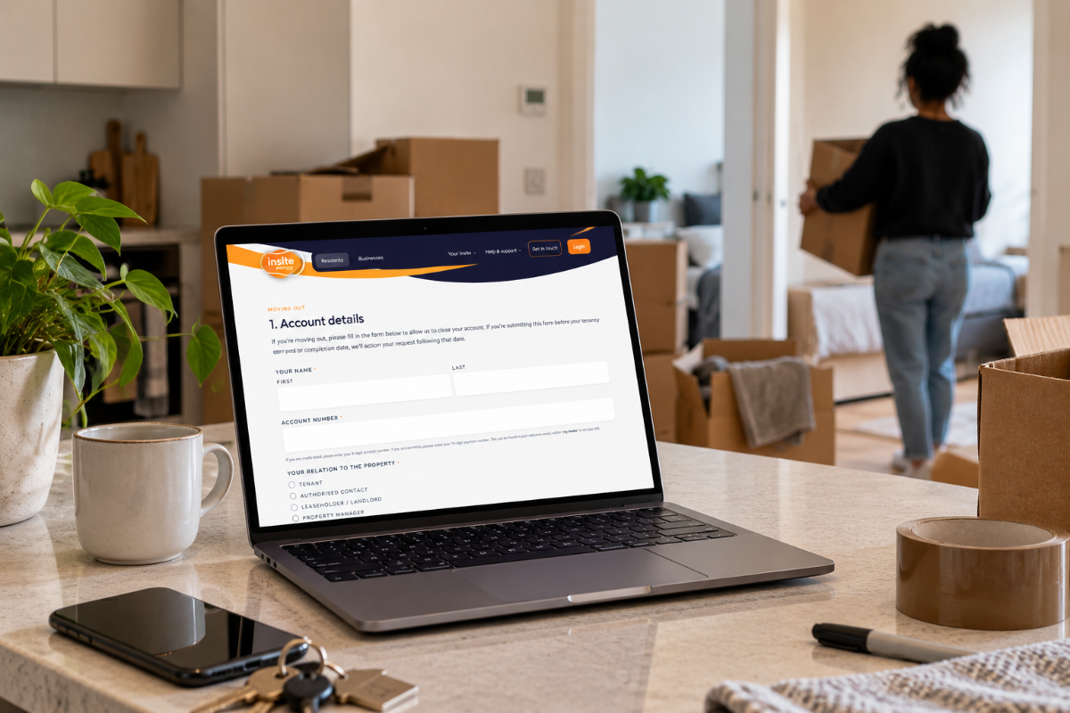 A laptop sits on the counter top with the Insite Energy moving out form displayed on-screen whilst a resident carries a box in the background.